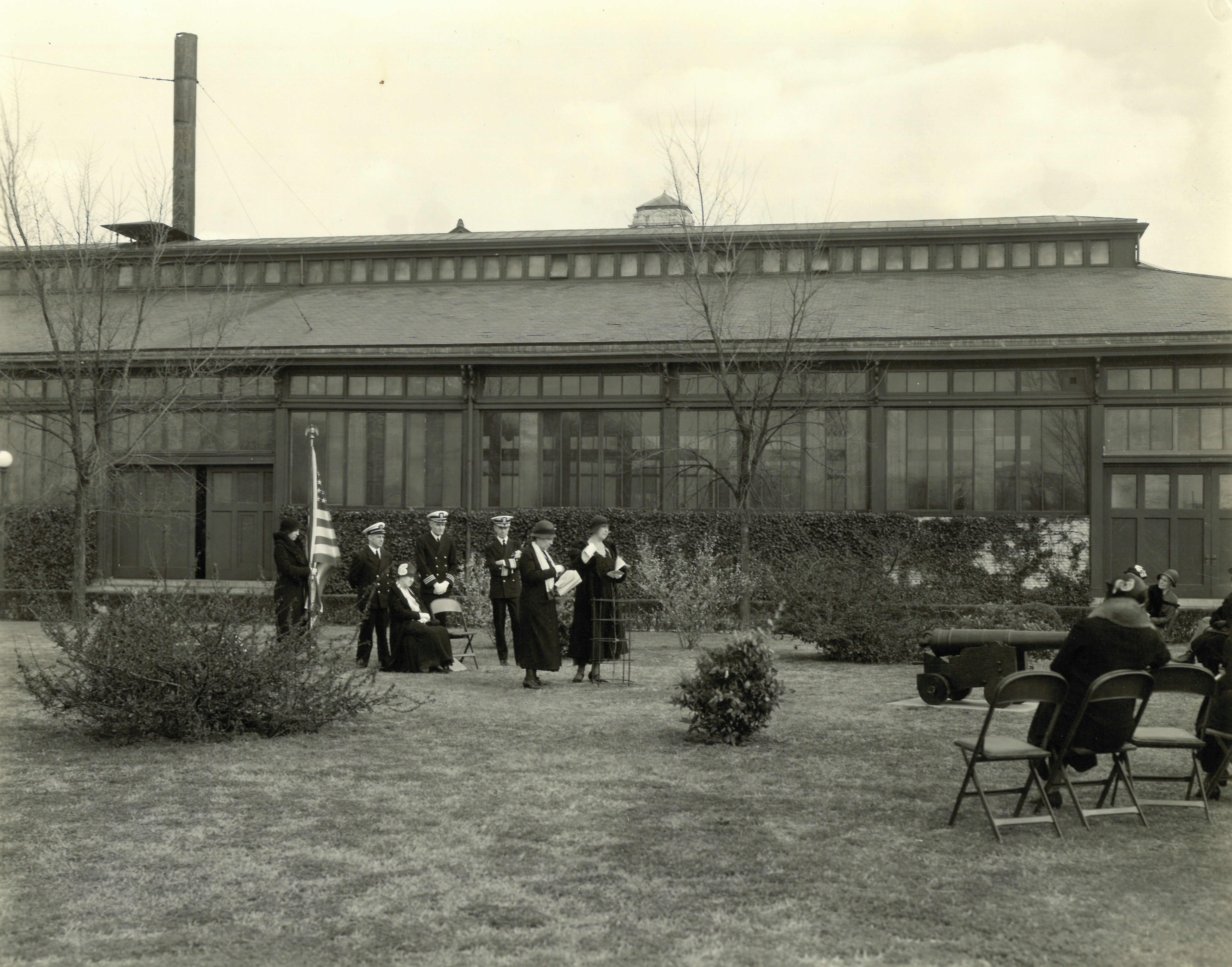The Washington Elm dedication with the Engineering & Aeronautics Building in the background. A Revolutionary War-era cannon sits to the right of the official party. In her correspondence with the Superintendent, Mrs. Alger had suggested that a cannon be placed near the tree.